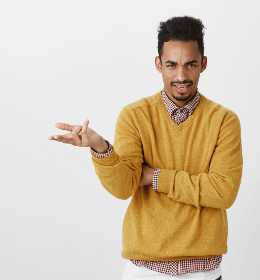 What do you want from me. Portrait of outraged clueless young guy with afro haircut and stylish outfit raising palm and shrugging, frowning with displeased expression, being unaware, arguing.