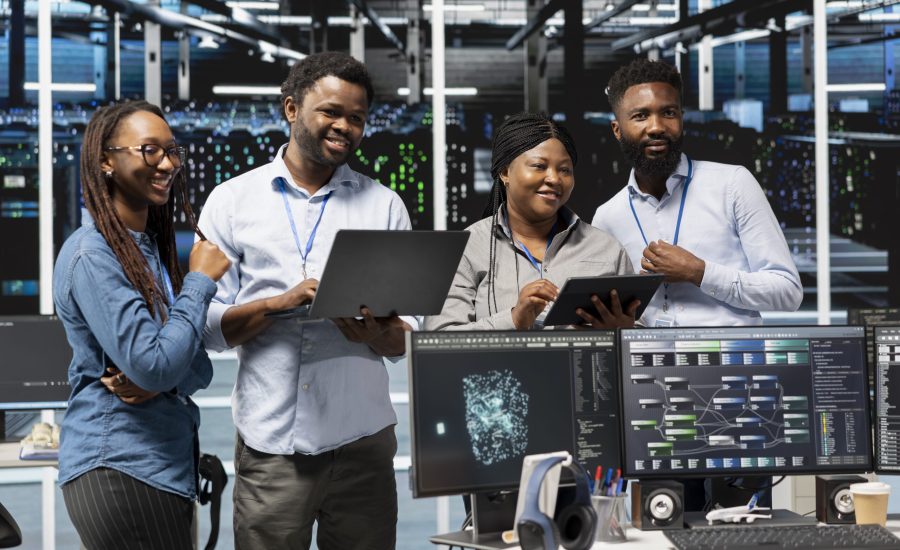 Cheerful data center experts working together, using deep learning algorithms and node trees to analyze datasets. Jolly server farm teamworking colleagues using AI to recognize facility data patterns